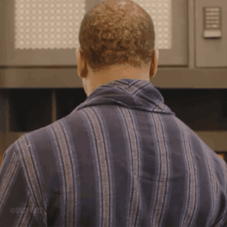 Man in Striped Shirt Standing in Front of Microwave