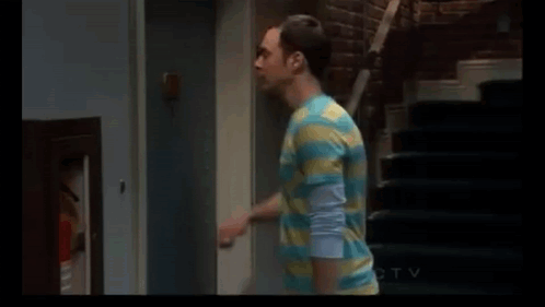 Man in Striped Shirt Standing Next to Door and Stairs