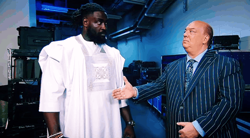 Man in Striped Suit Talks to Man in White Shirt
