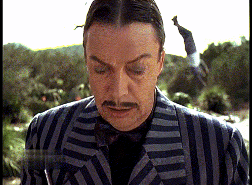 Man in Striped Suit With Mustache Looking Down