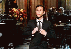 Man In Suit Adjusting Tie On Stage GIF