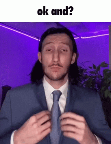 Man in Suit Adjusting Tie Saying OK And