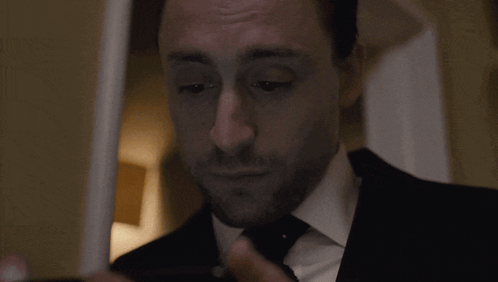 Man In Suit Adjusts Tie Before Mirror GIF