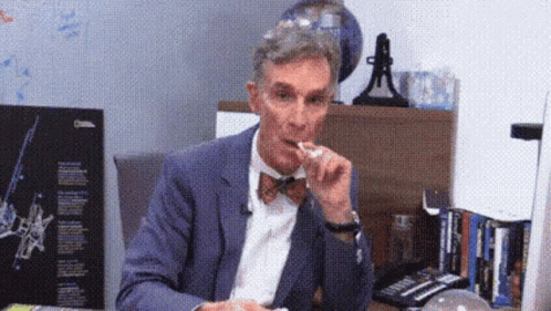 Man in Suit and Bow Tie Eating Food