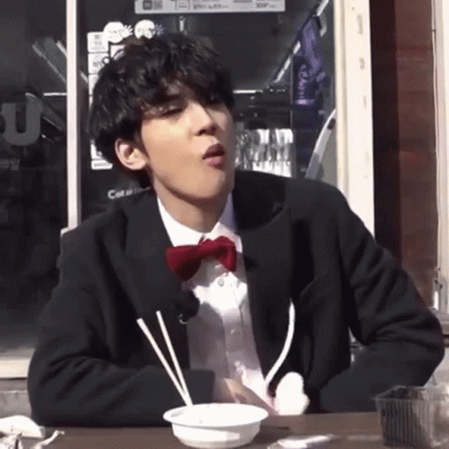 Man In Suit And Bow Tie Eating GIF