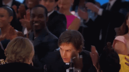 Man in Suit and Bow Tie Standing Before Crowd