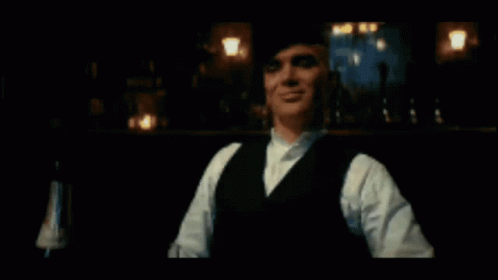 Man In Suit And Bow Tie Walking Down Street With Netflix Logo GIF