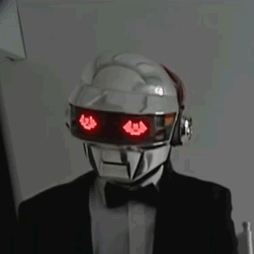 Man in Suit and Bow Tie With Red-Eyed Robot Helmet