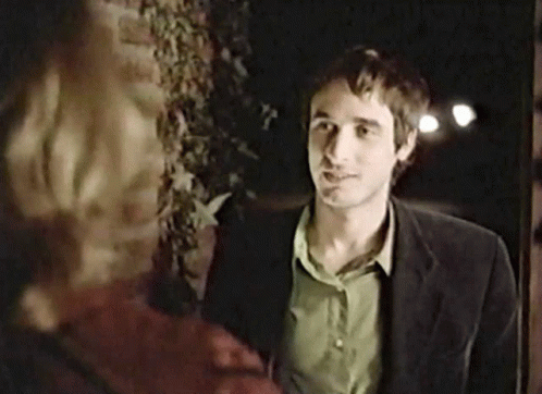 Man In Suit And Green Shirt In Front Of Brick Wall GIF