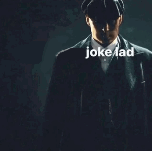 Man in Suit and Hat in Dark With Jokelad