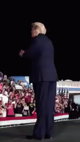 Man in Suit and Hat on Stage in Front of Crowd