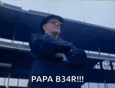 Man In Suit And Hat Standing In Front Of Stadium Arms Crossed Says Papa B34r GIF
