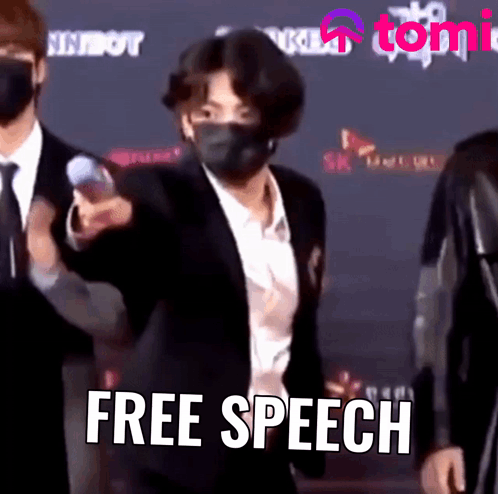 Man In Suit And Mask Standing In Front Of Free Speech Sign GIF