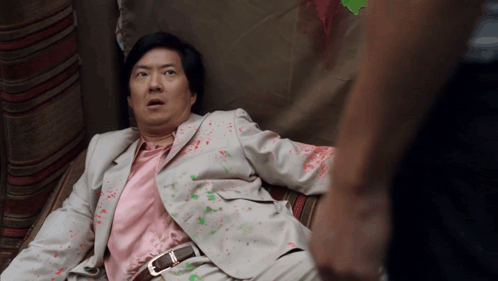 Man In Suit And Pink Shirt Lying Down GIF