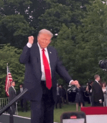 Man in Suit and Red Tie Dancing in Front of Crowd
