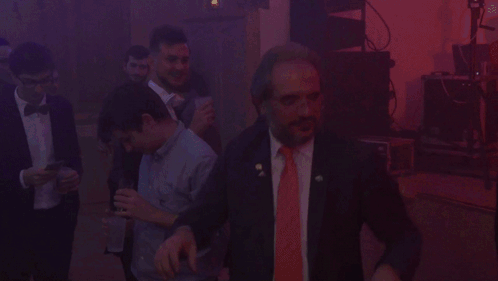 Man in Suit and Red Tie in Dark Room