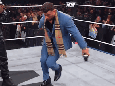 Man in Suit and Scarf in AEW Ring