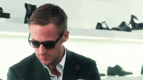 Man in Suit and Sunglasses Looking Down