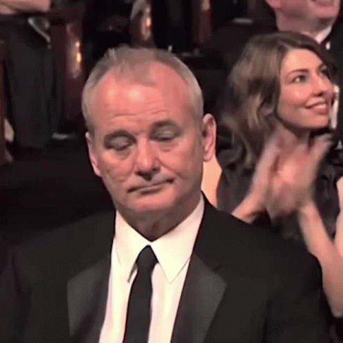Man in Suit and Tie Applauding in Crowd