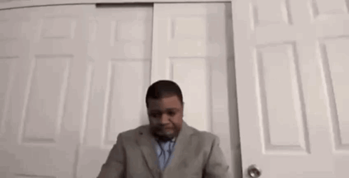 Man in Suit and Tie at Closet Door