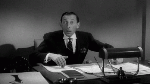 Man In Suit And Tie At Desk With Papers GIF