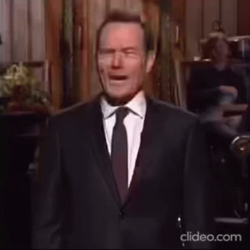 Man in Suit and Tie at Microphone on Stage