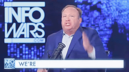 Man in Suit and Tie at Microphone with M