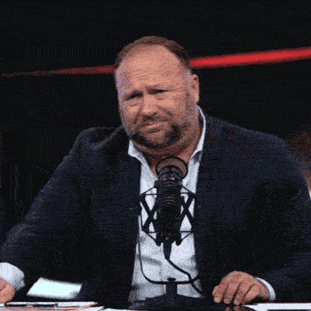 Man in Suit and Tie at Microphone with X
