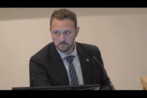 Man in Suit and Tie at Podium