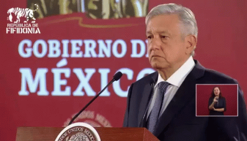 Man in Suit and Tie at Podium Saying Gobierno de Mexico