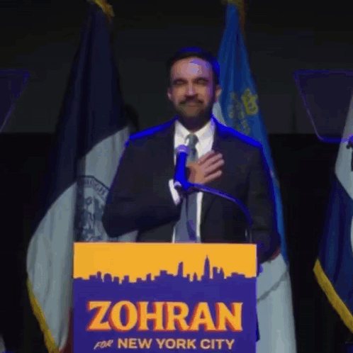 Man in Suit and Tie at Podium Saying Zohran for New York City