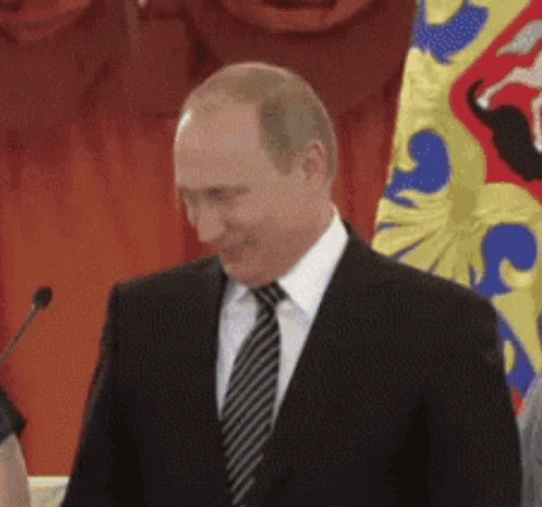 Man In Suit And Tie Before Flag GIF