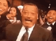 Man In Suit And Tie Before Laughing Crowd GIF