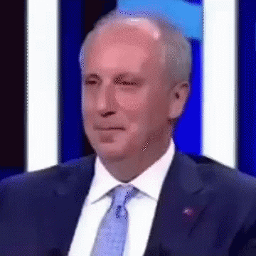 Man In Suit And Tie Beside Blue Wall GIF