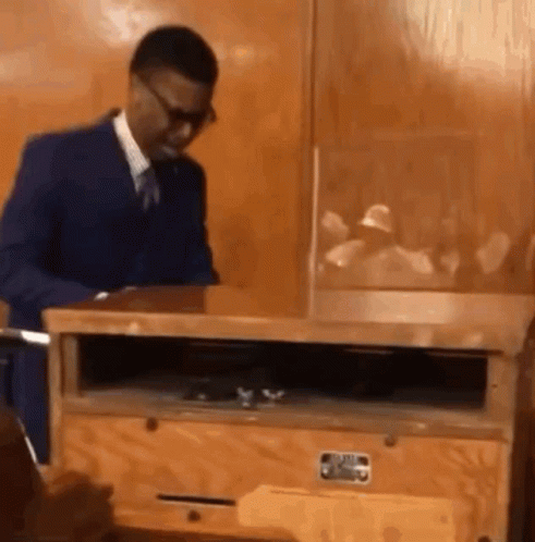 Man in Suit and Tie by Wooden Box