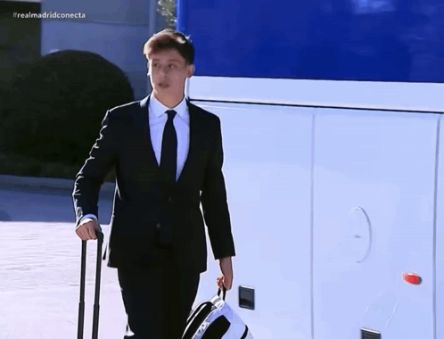 Man in Suit and Tie Carrying Suitcase Realmadridconnecta