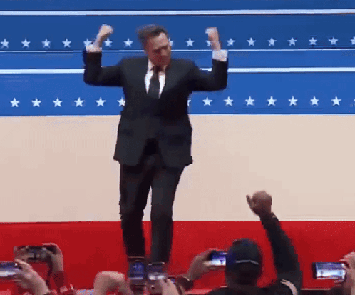 Man in Suit and Tie Dancing Before Star Flag