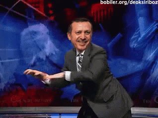 Man in Suit and Tie Dancing in Front of Screen Saying bobller.org/deoksiriboz