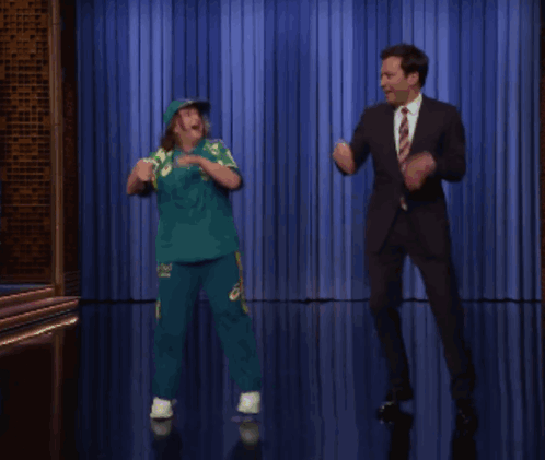 Man in Suit and Tie Dancing with Girl in Green