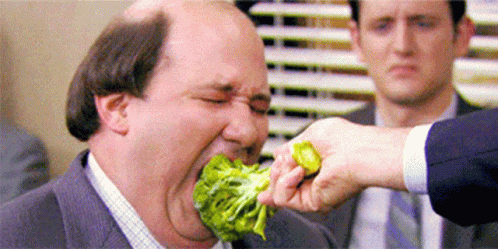 Man in Suit and Tie Eating Broccoli