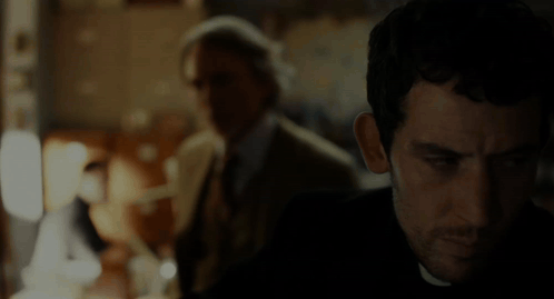 Man in Suit and Tie Eyes Closed in Dark Room
