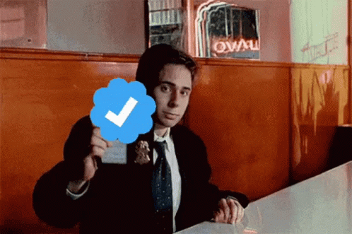 Man in Suit and Tie Holding Check Mark
