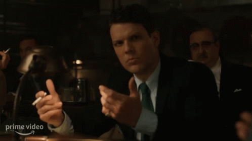 Man in Suit and Tie Holding Cigarette at Prime Video Sign