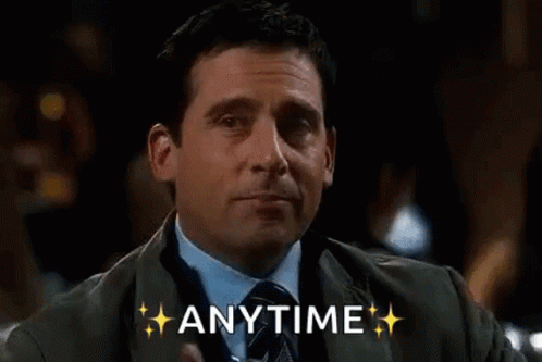 Man in Suit and Tie Holding Drink Saying Anytime