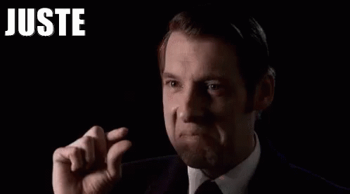 Man in Suit and Tie Holding Finger to Forehead