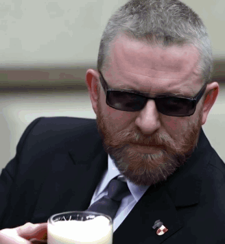 Man In Suit And Tie Holding Glass Of Milk GIF