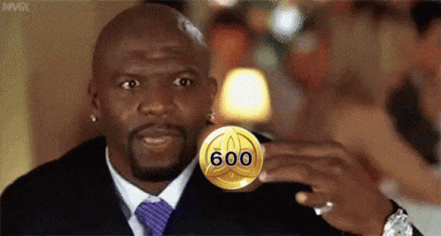 Man in Suit and Tie Holding Gold Coin Saying 600