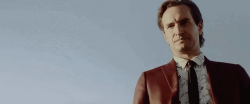 Man in Suit and Tie Holding Gun