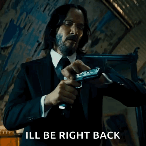 Man in Suit and Tie Holding Gun