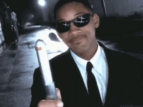 Man in Suit and Tie Holding Gun With Sunglasses